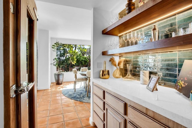 bar featuring light tile patterned flooring and decorative backsplash