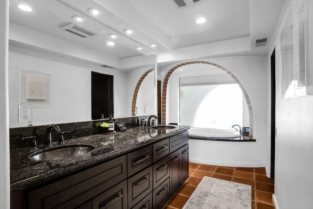 bathroom featuring tile patterned floors, vanity, and a bath