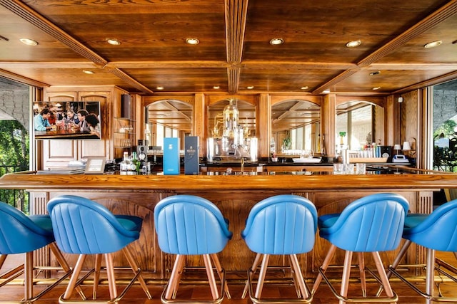 bar with hardwood / wood-style floors, coffered ceiling, wooden ceiling, and beam ceiling