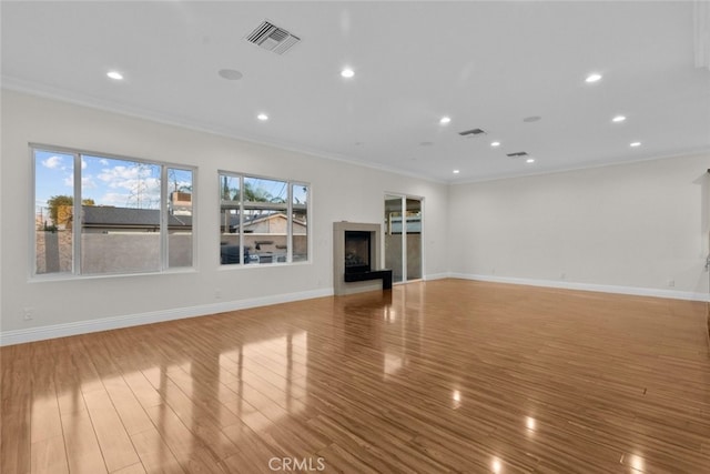 unfurnished living room featuring crown molding and light hardwood / wood-style floors