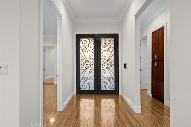 foyer entrance featuring ornamental molding, light hardwood / wood-style flooring, and french doors