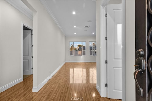 hallway featuring light hardwood / wood-style floors and ornamental molding