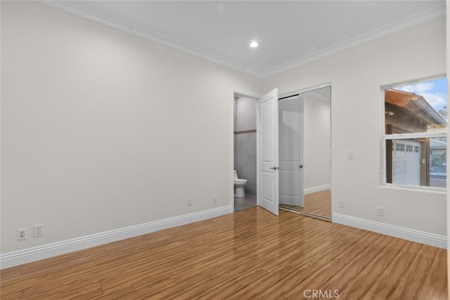 unfurnished bedroom with ornamental molding, wood-type flooring, and a closet