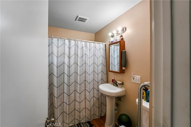 bathroom with hardwood / wood-style floors, sink, and toilet