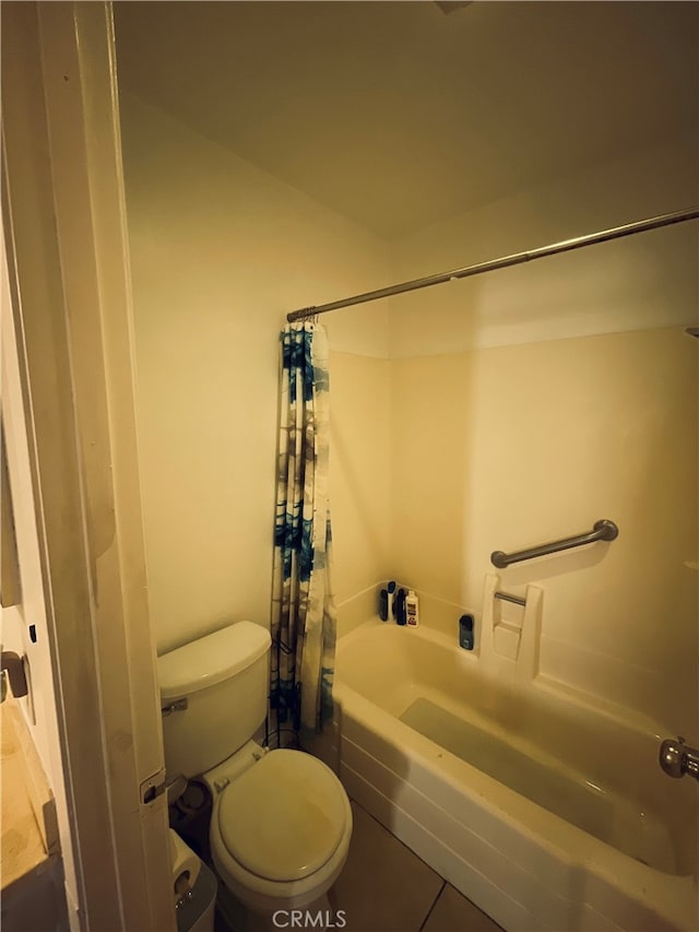 bathroom with tile patterned floors, shower / tub combo, and toilet