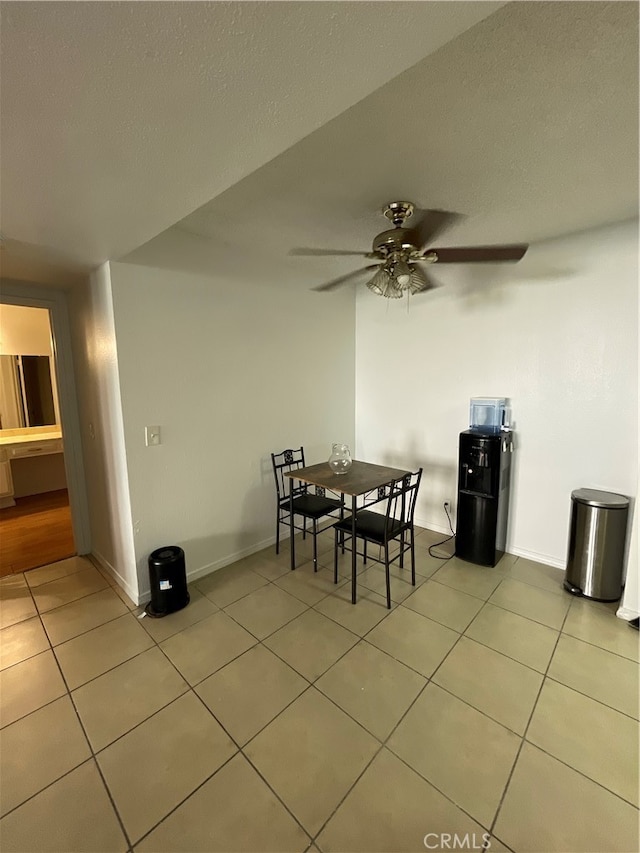 tiled dining room featuring a textured ceiling and ceiling fan