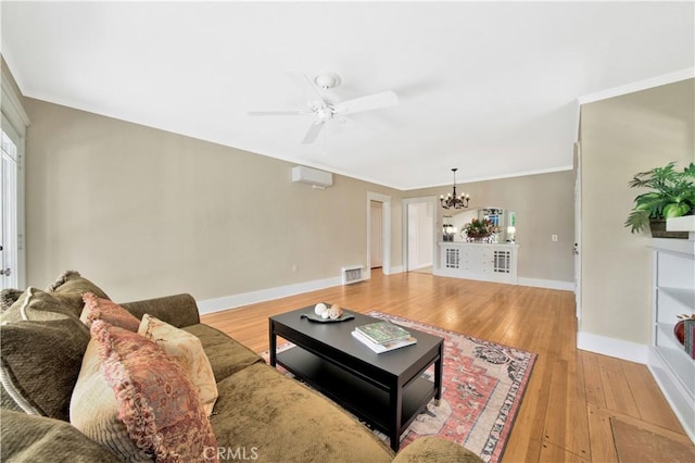 living room featuring crown molding, light wood-type flooring, an AC wall unit, and ceiling fan with notable chandelier