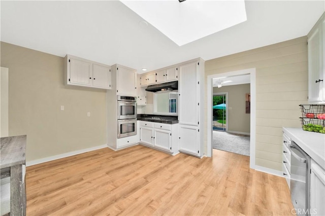 kitchen featuring stainless steel appliances, light hardwood / wood-style flooring, and white cabinets