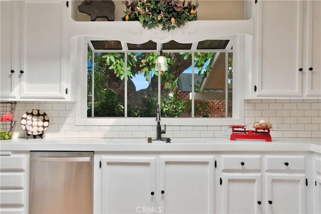 kitchen with white cabinetry, stainless steel dishwasher, tasteful backsplash, and sink