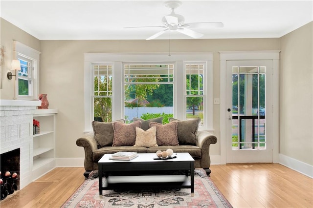 sunroom with ceiling fan and a brick fireplace