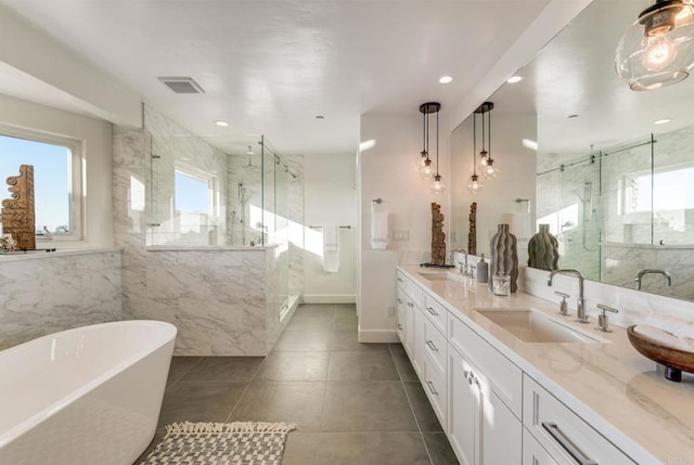 bathroom with tile patterned floors, vanity, shower with separate bathtub, and tile walls