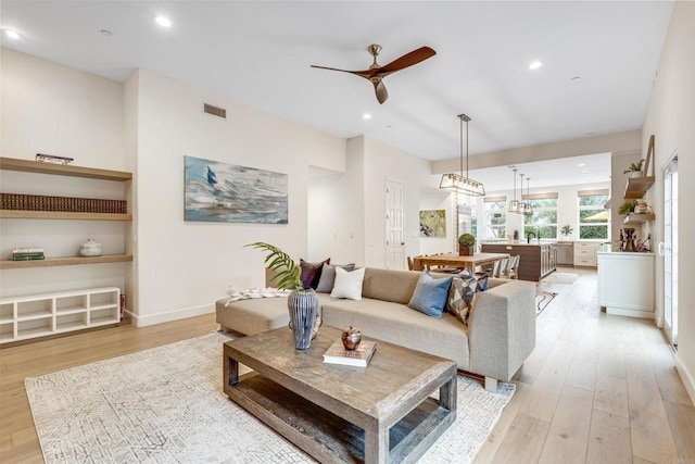 living room featuring sink, light hardwood / wood-style floors, and ceiling fan