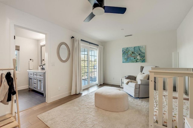 bedroom featuring access to exterior, light hardwood / wood-style flooring, ceiling fan, and ensuite bathroom