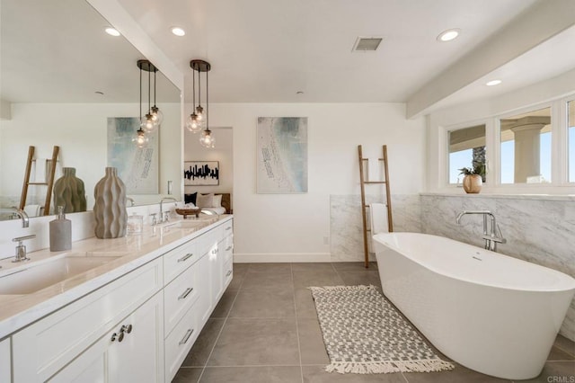 bathroom with vanity, tile walls, tile patterned floors, and a bathtub