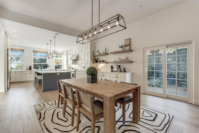 dining area featuring sink, track lighting, and light wood-type flooring