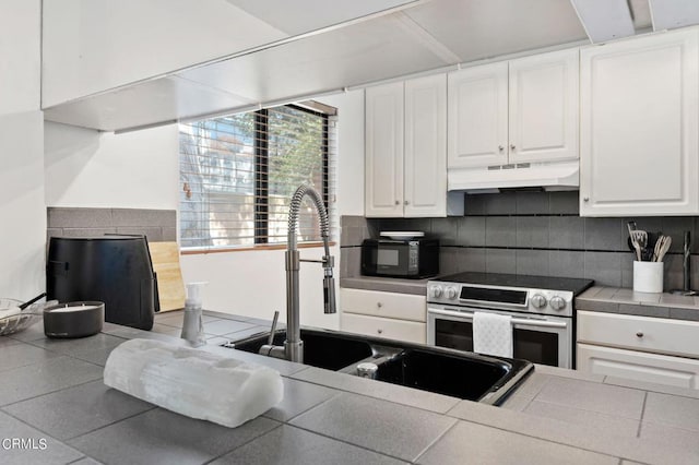 kitchen with white cabinets, tile countertops, tasteful backsplash, and electric range