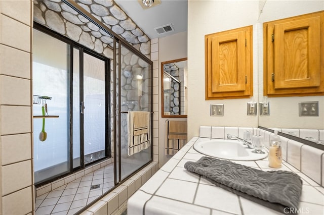 bathroom with tile patterned flooring, vanity, and a shower with shower door