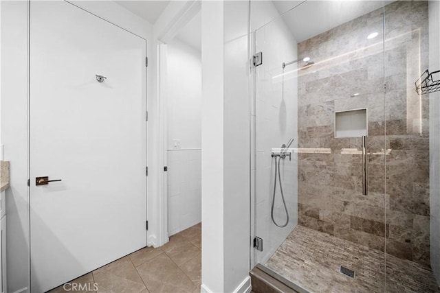 bathroom featuring tile patterned flooring, vanity, and a shower with door