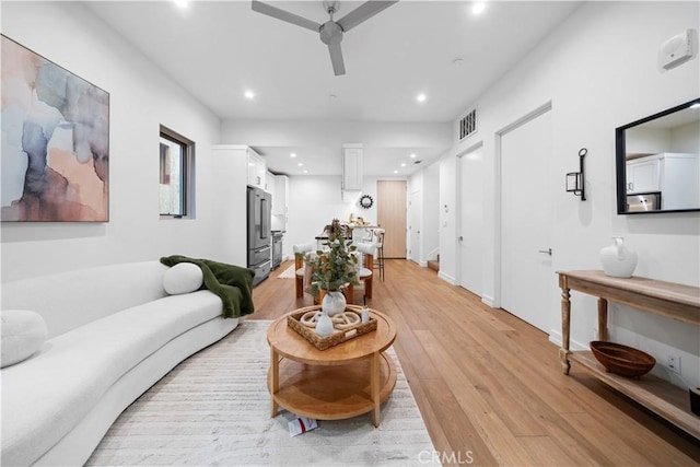 living room featuring ceiling fan and light hardwood / wood-style floors