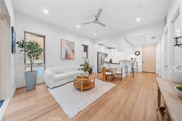 living room featuring ceiling fan and light wood-type flooring