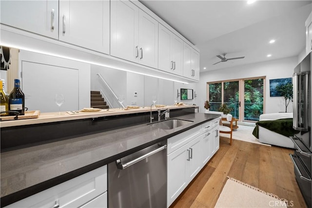 kitchen featuring sink, white cabinets, stainless steel appliances, and light wood-type flooring