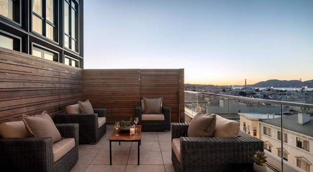 balcony at dusk featuring an outdoor living space