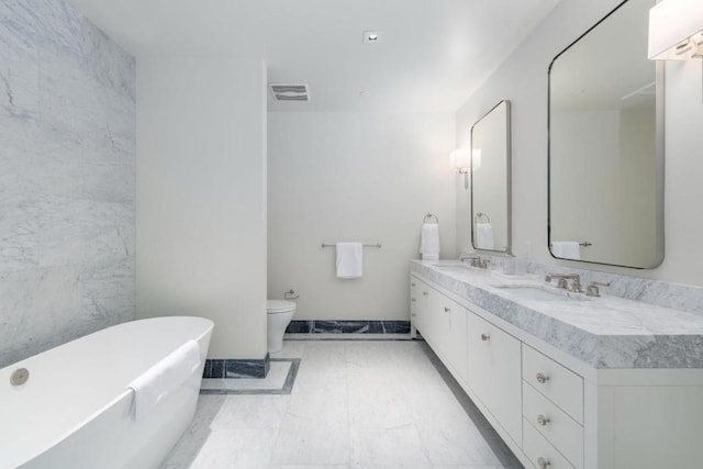 bathroom featuring a tub to relax in, vanity, and toilet