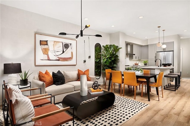 living room with light wood-type flooring and an inviting chandelier