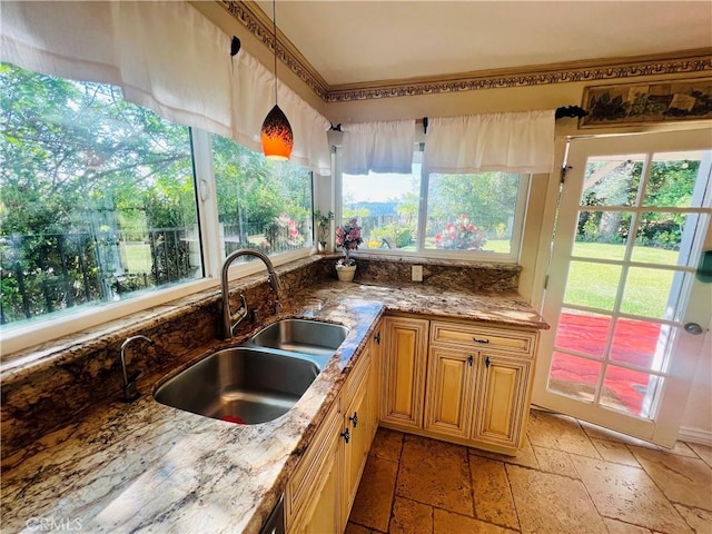 kitchen with pendant lighting, sink, and stone counters