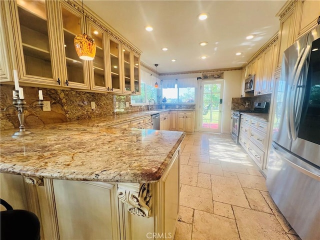 kitchen featuring pendant lighting, decorative backsplash, light stone countertops, and stainless steel appliances