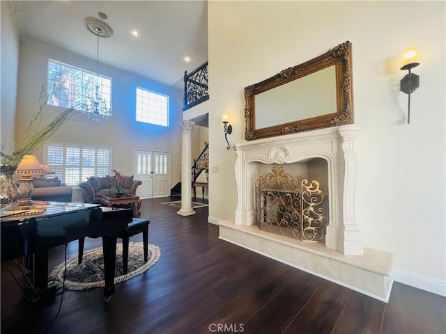 interior space with a high ceiling, ornate columns, and dark wood-type flooring