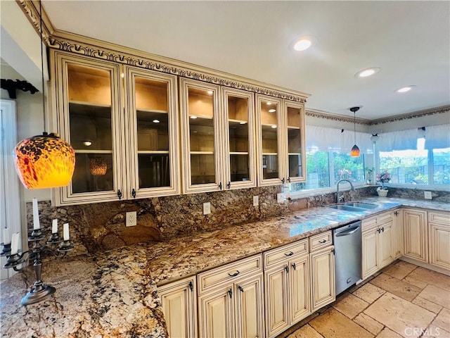 kitchen with cream cabinets, hanging light fixtures, stainless steel dishwasher, tasteful backsplash, and light stone counters