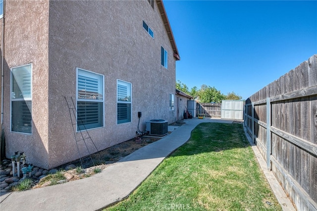 exterior space featuring cooling unit and a lawn