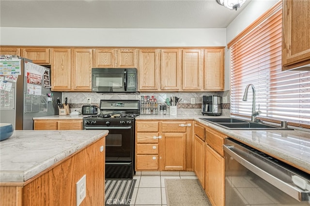 kitchen with tasteful backsplash, sink, light tile patterned floors, and black appliances