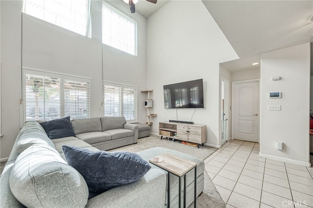 living room with ceiling fan, high vaulted ceiling, and light tile patterned floors