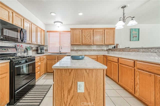 kitchen with a center island, sink, decorative light fixtures, light tile patterned flooring, and black appliances