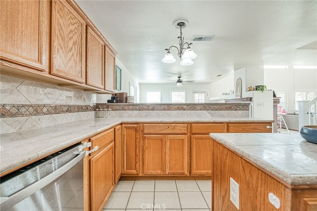 kitchen featuring tasteful backsplash, ceiling fan with notable chandelier, pendant lighting, dishwasher, and light tile patterned flooring