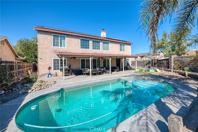 view of pool with grilling area and a patio