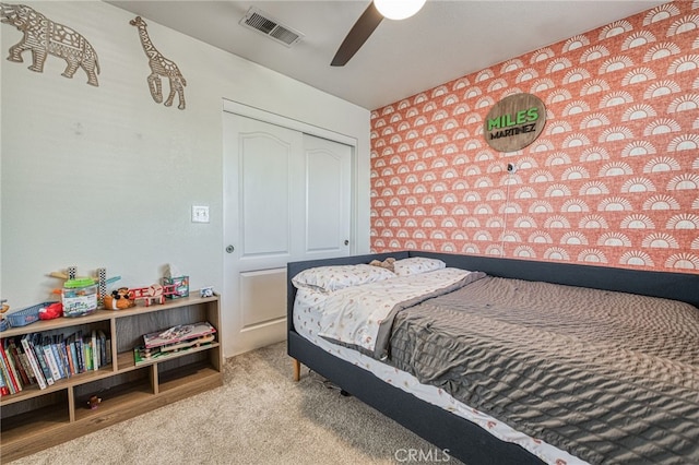 bedroom with carpet, ceiling fan, and a closet