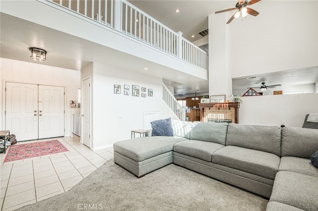 tiled living room with a high ceiling and ceiling fan