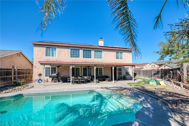 view of swimming pool featuring a patio, ceiling fan, and grilling area