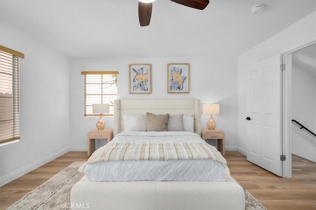 bedroom featuring light wood-type flooring, multiple windows, and ceiling fan