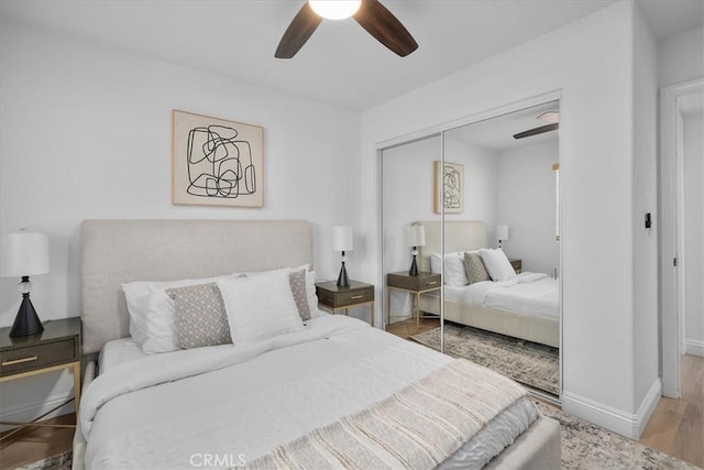 bedroom with hardwood / wood-style flooring, a closet, and ceiling fan