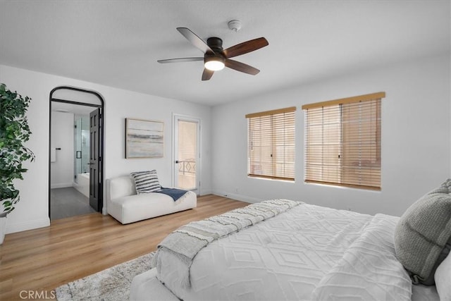 bedroom featuring ceiling fan, light hardwood / wood-style floors, and ensuite bath