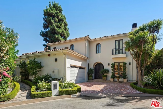 mediterranean / spanish house with french doors and a balcony