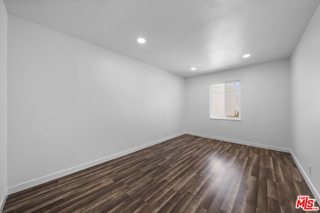 empty room with dark hardwood / wood-style flooring