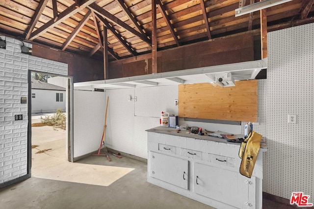 interior space with a workshop area and vaulted ceiling