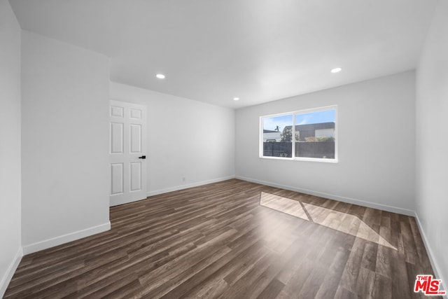 unfurnished room with dark hardwood / wood-style flooring