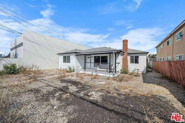 rear view of property with covered porch