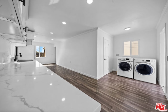 laundry area with washer and clothes dryer, crown molding, dark wood-type flooring, and sink